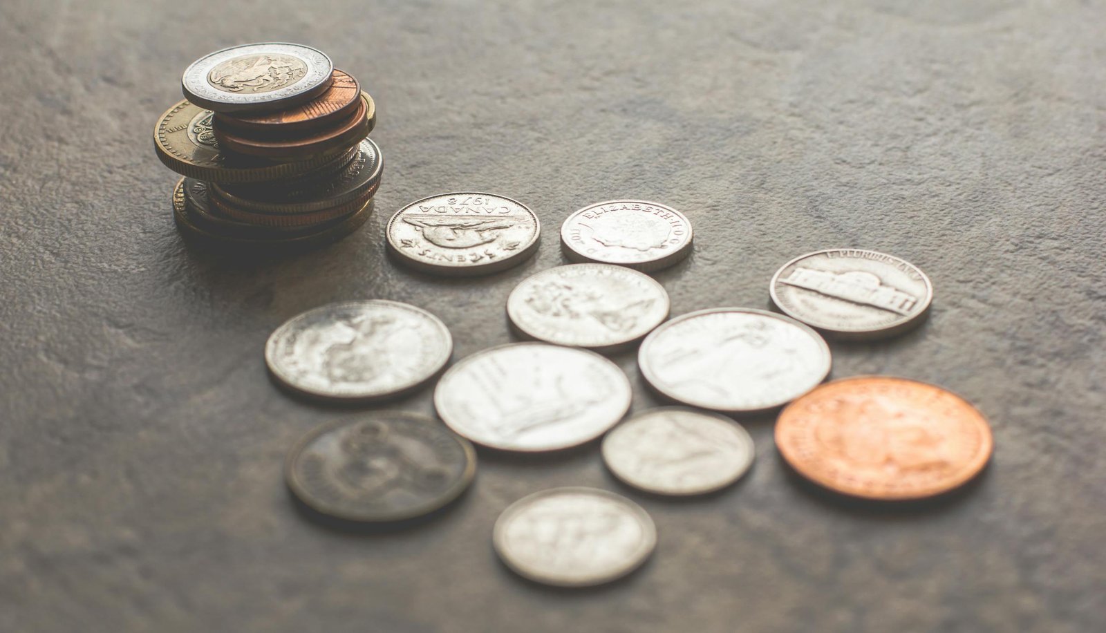 Assorted Silver-and-gold-colored Coins on Gray Surface