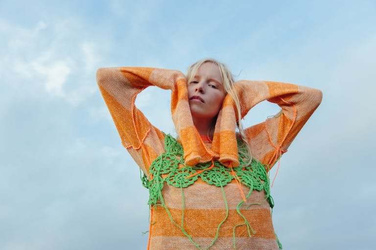 A Woman in Orange Knit Sweater and Green Crochet Top