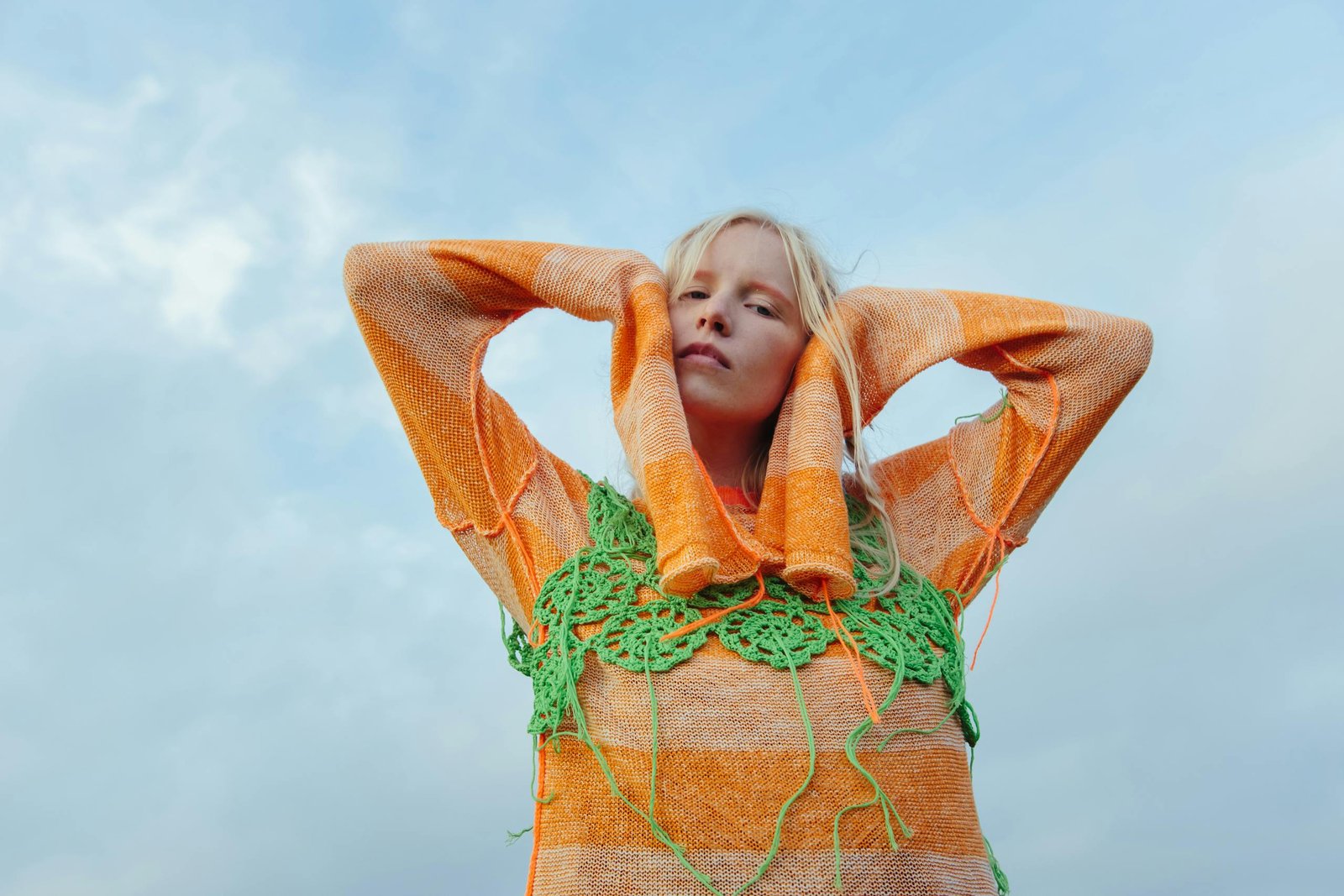 A Woman in Orange Knit Sweater and Green Crochet Top