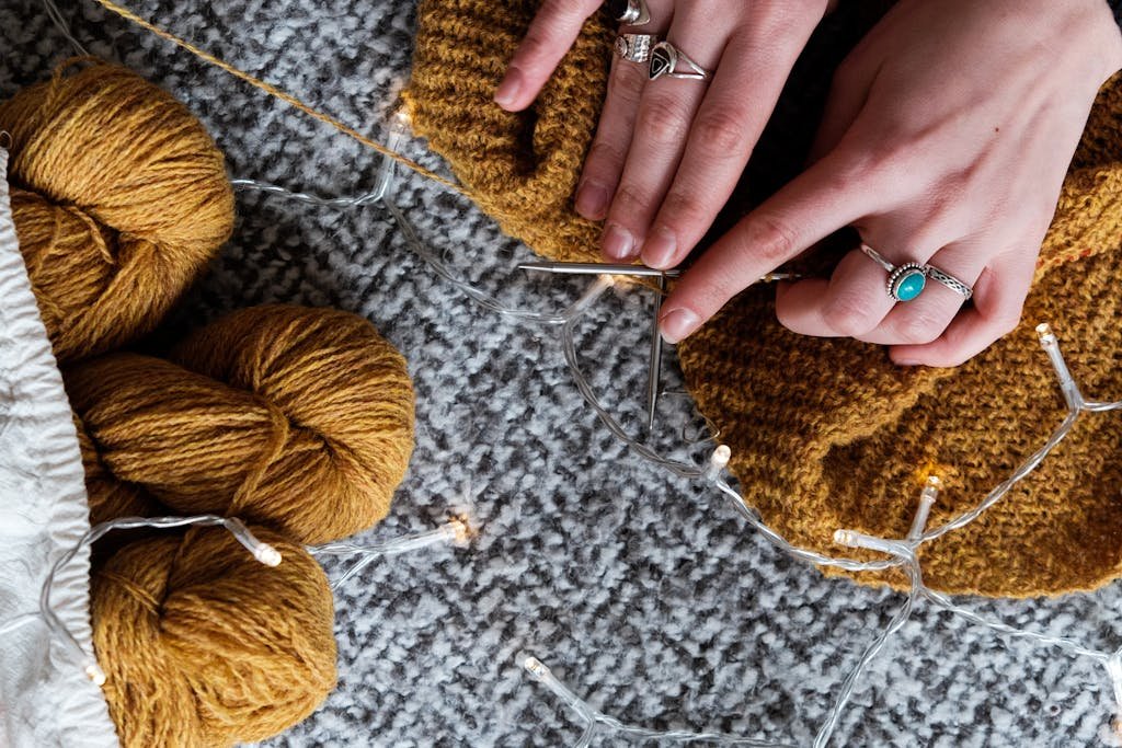 Photo Of Person Holding Brown Yarn Roll